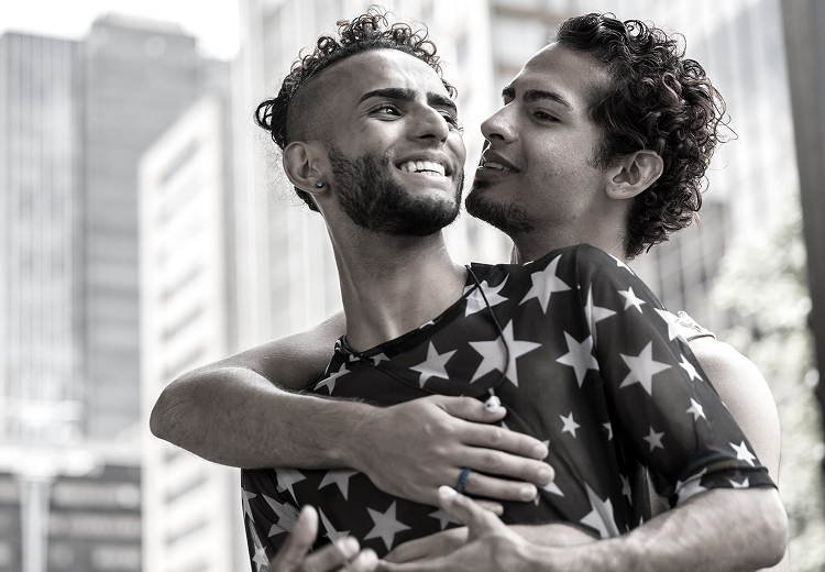 Pareja abrazándose y sonriendo en la ciudad