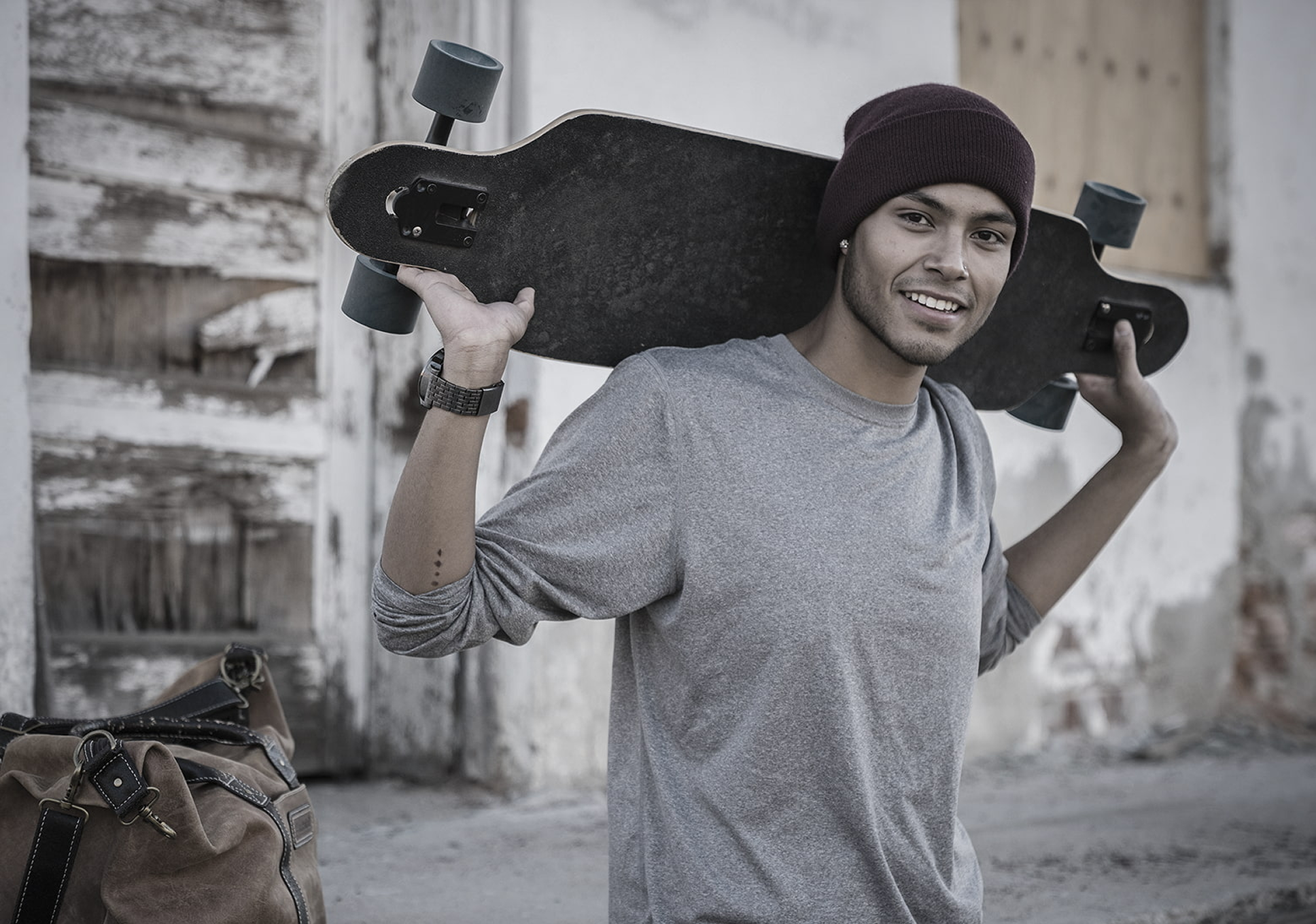 Joven sosteniendo una patineta sobre el hombro