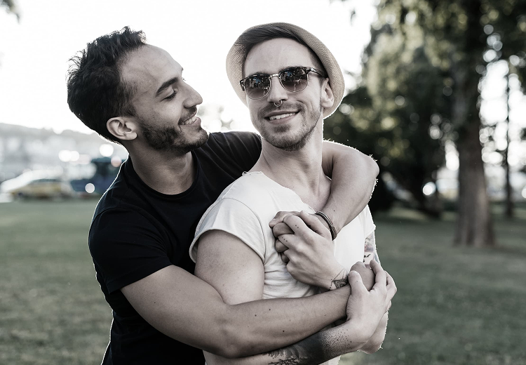 Pareja abrazándose y sonriendo en un parque