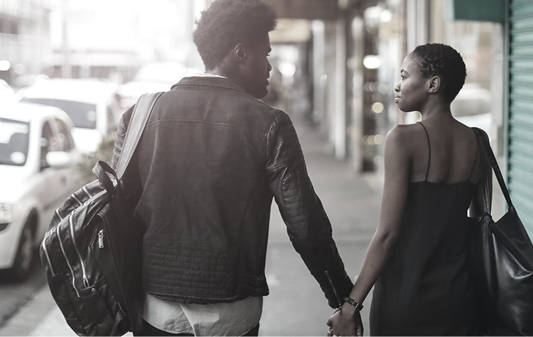 Pareja caminando de la mano por una calle de la ciudad